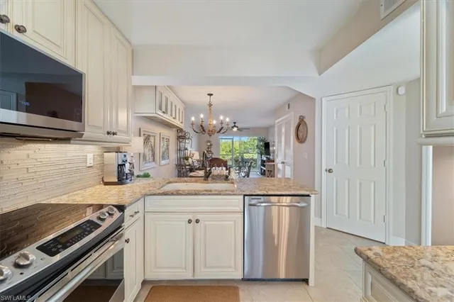 a kitchen with white cabinets and appliances