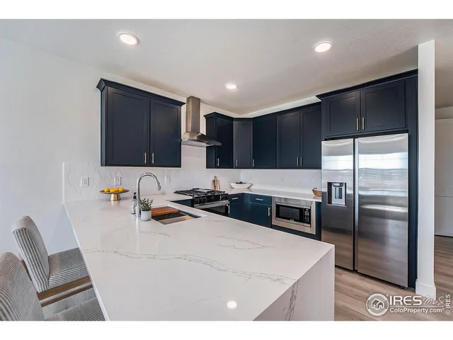 a kitchen with kitchen island a counter top space cabinets and stainless steel appliances
