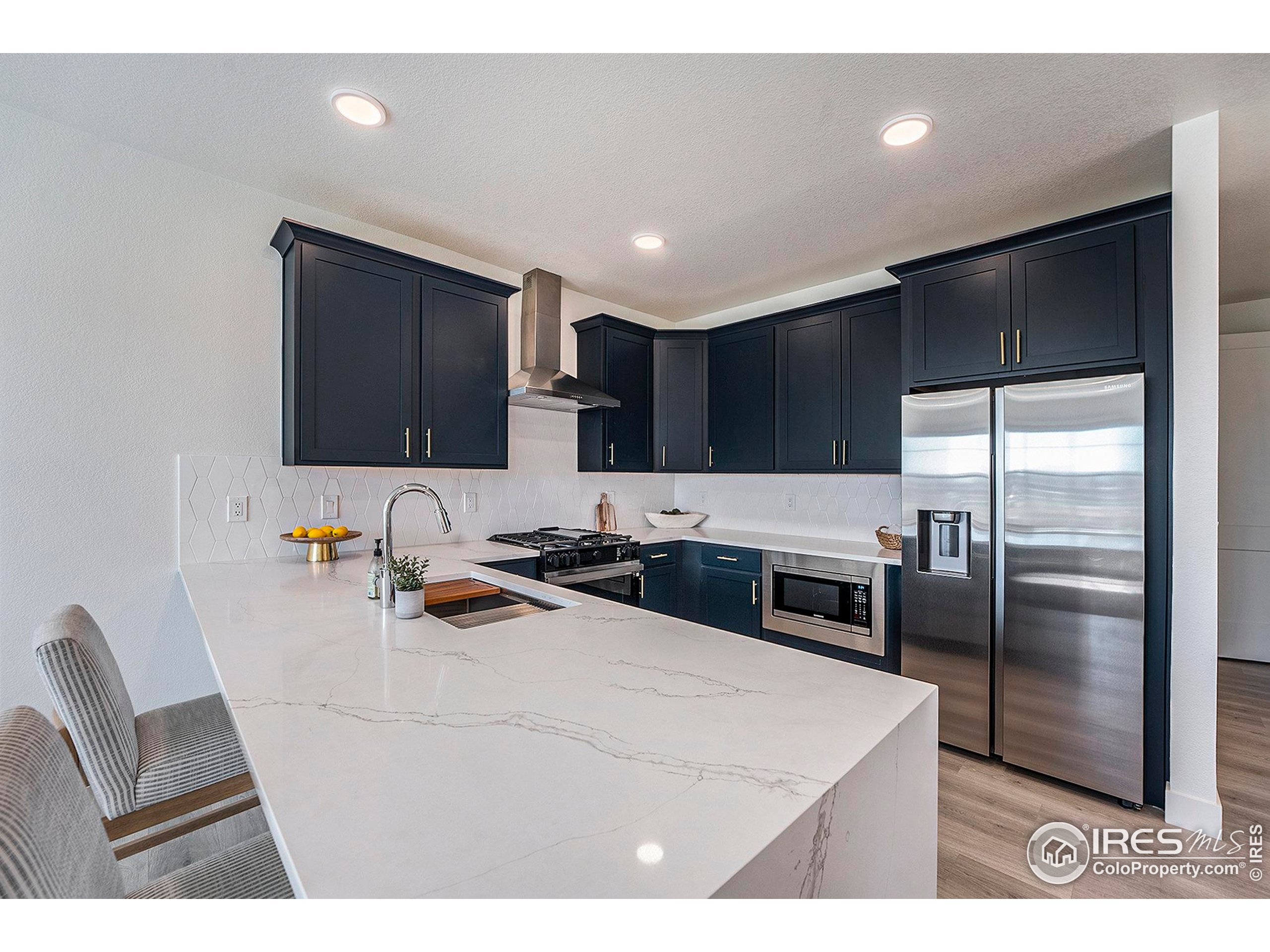 5001 Avon Avenue Loveland, CO 80538 - Photo 1 of 16 a kitchen with kitchen island a counter top space cabinets and stainless steel appliances