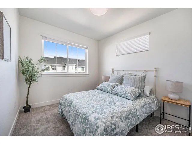 a bedroom with a bed and a potted plant