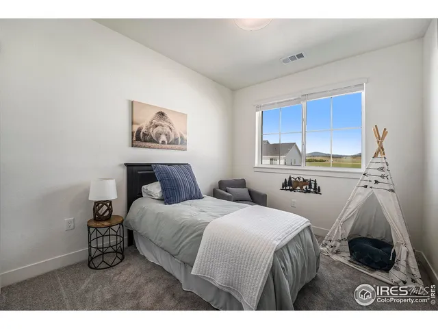 a bedroom with a bed a couch and a window