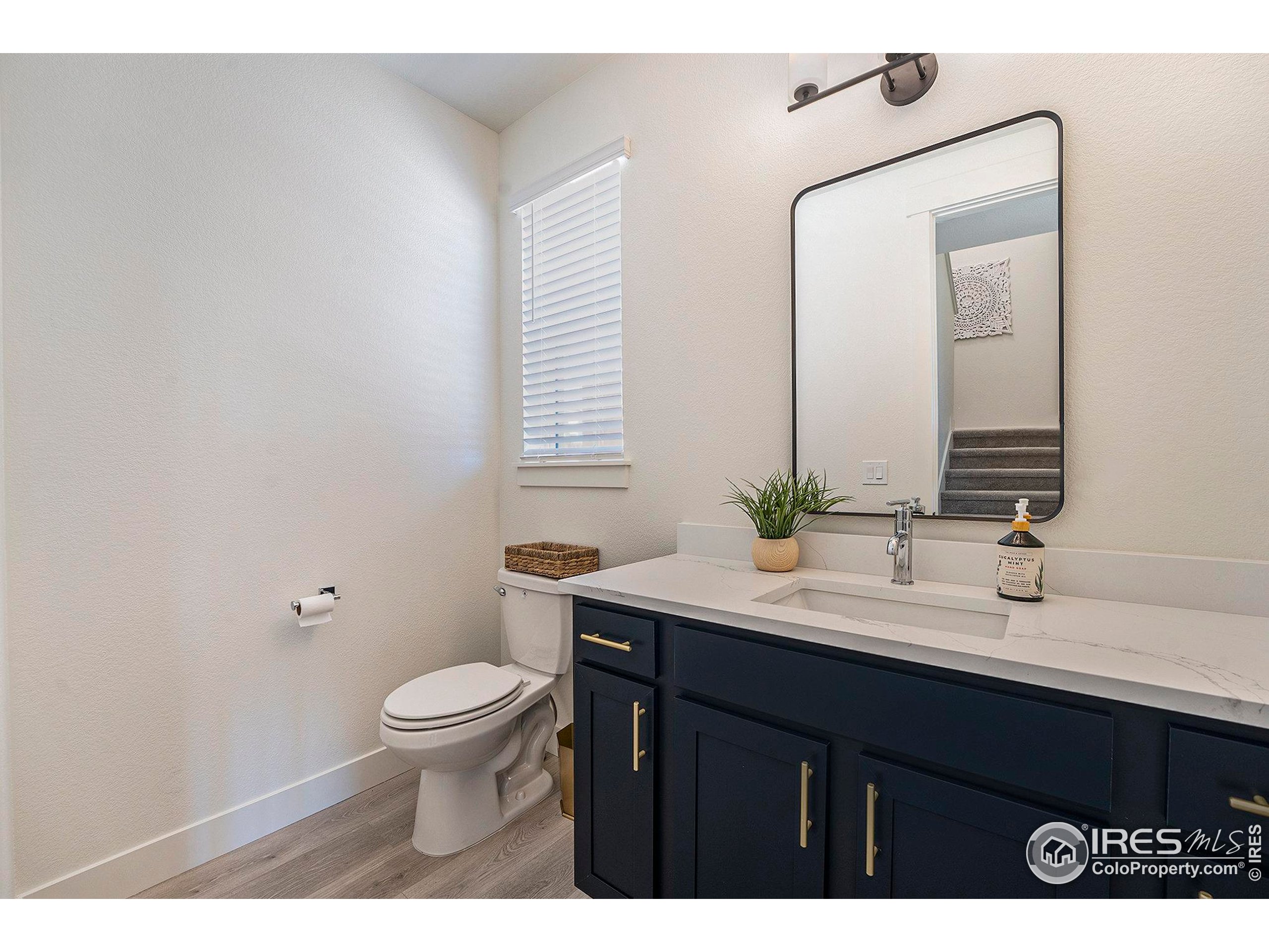 5001 Avon Avenue Loveland, CO 80538 - Photo 7 of 16 a bathroom with a granite countertop sink a toilet and a mirror