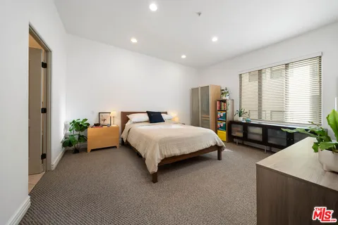 a spacious bedroom with a bed a couch and dresser