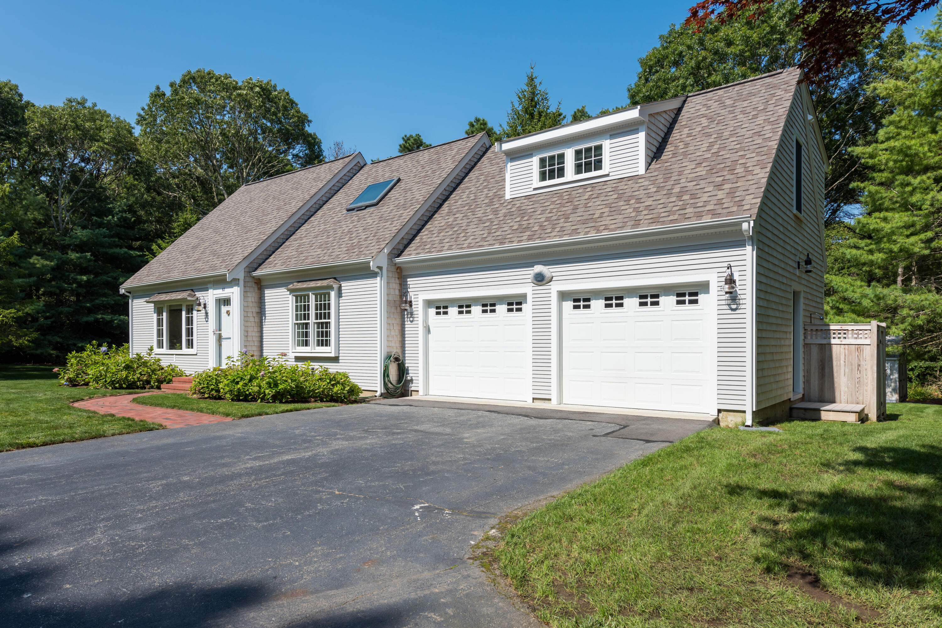 68 Tupelo Road Marstons Mills, MA 02648 - Photo 2 of 29 a front view of a house with a garden and plants