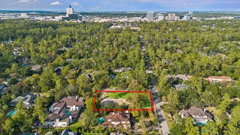 an aerial view of residential houses with outdoor space and trees