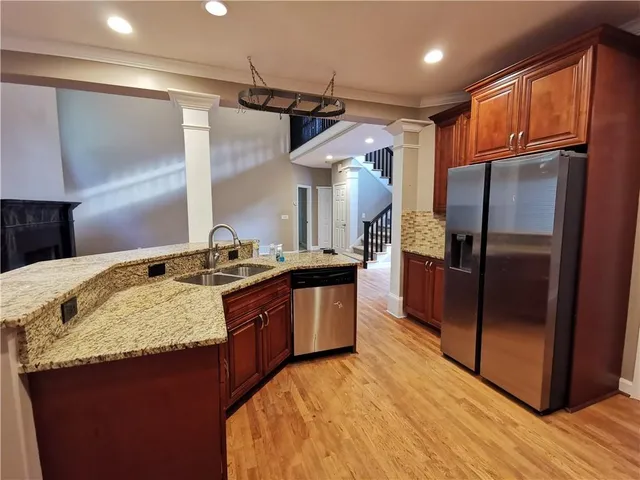 a kitchen with stainless steel appliances granite countertop a sink a stove and a refrigerator