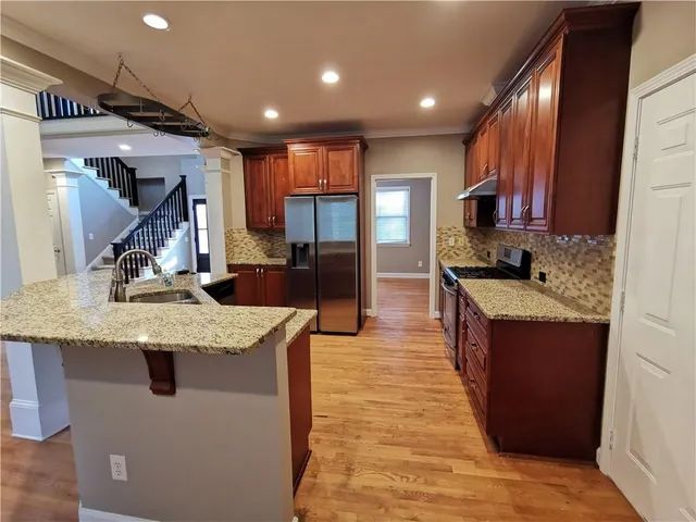 a kitchen with stainless steel appliances granite countertop sink stove top oven and cabinets