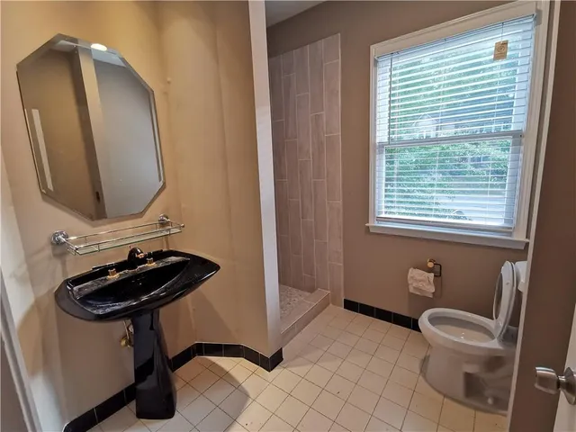 a bathroom with a toilet a sink and mirror