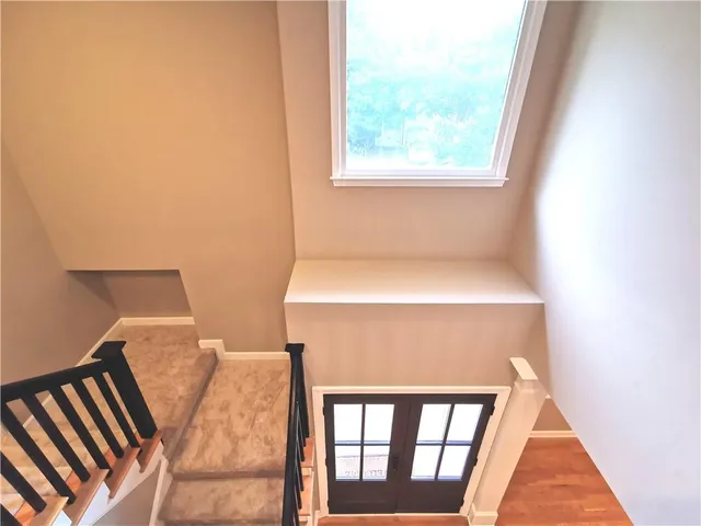 a view of a hallway with wooden floor and stairs