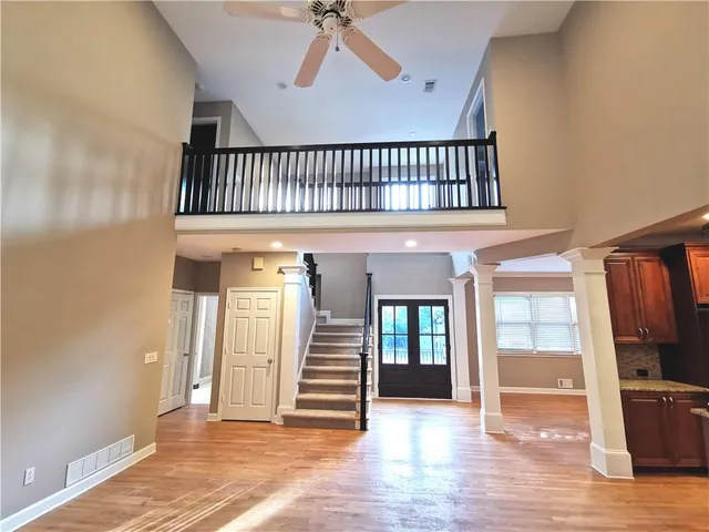 a view of a livingroom with wooden floor and stairs