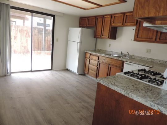 409 South Sunset Street Ridgecrest, CA 93555 - Photo 6 of 19 a kitchen with stainless steel appliances granite countertop a stove a sink and a refrigerator