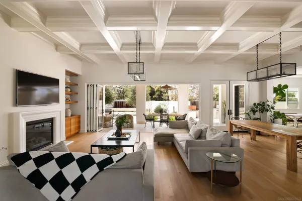 a living room with couches a flat screen tv and kitchen view