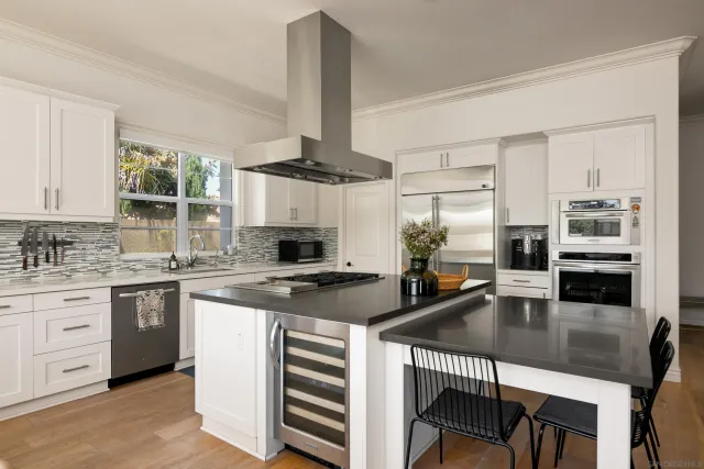 a kitchen with stainless steel appliances granite countertop a stove refrigerator and cabinets