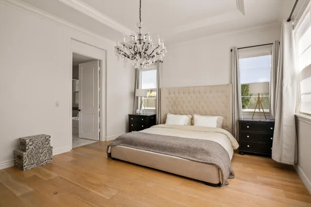 a bedroom with a large bed and a chandelier