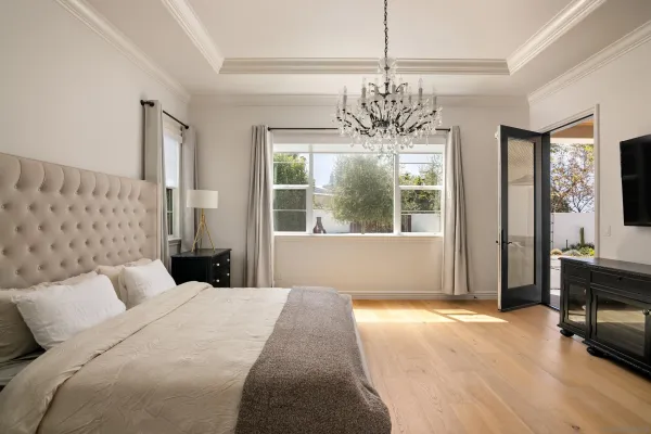 a bedroom with a large bed and a chandelier