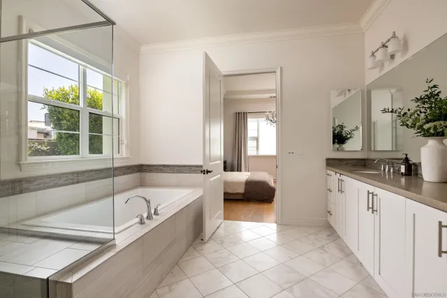 a spacious bathroom with a tub a double vanity sink and mirror