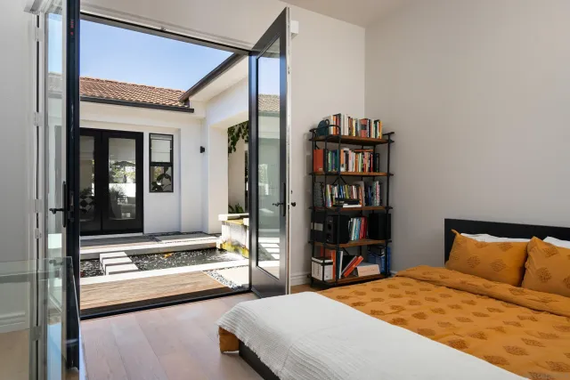 a bedroom with a large bed and a book shelf