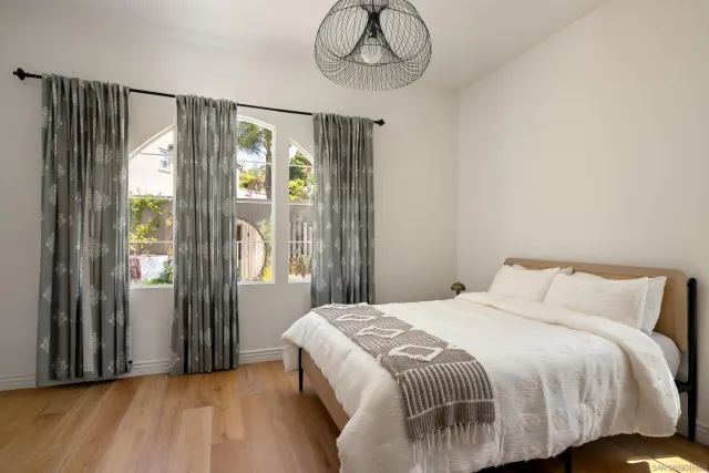 a bedroom with a bed and wooden floor