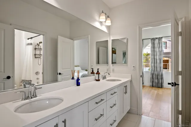 a bathroom with double vanity sinks a vanity a mirror and a shower
