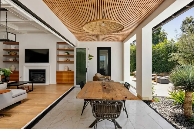 a living room with furniture a fireplace and a floor to ceiling window
