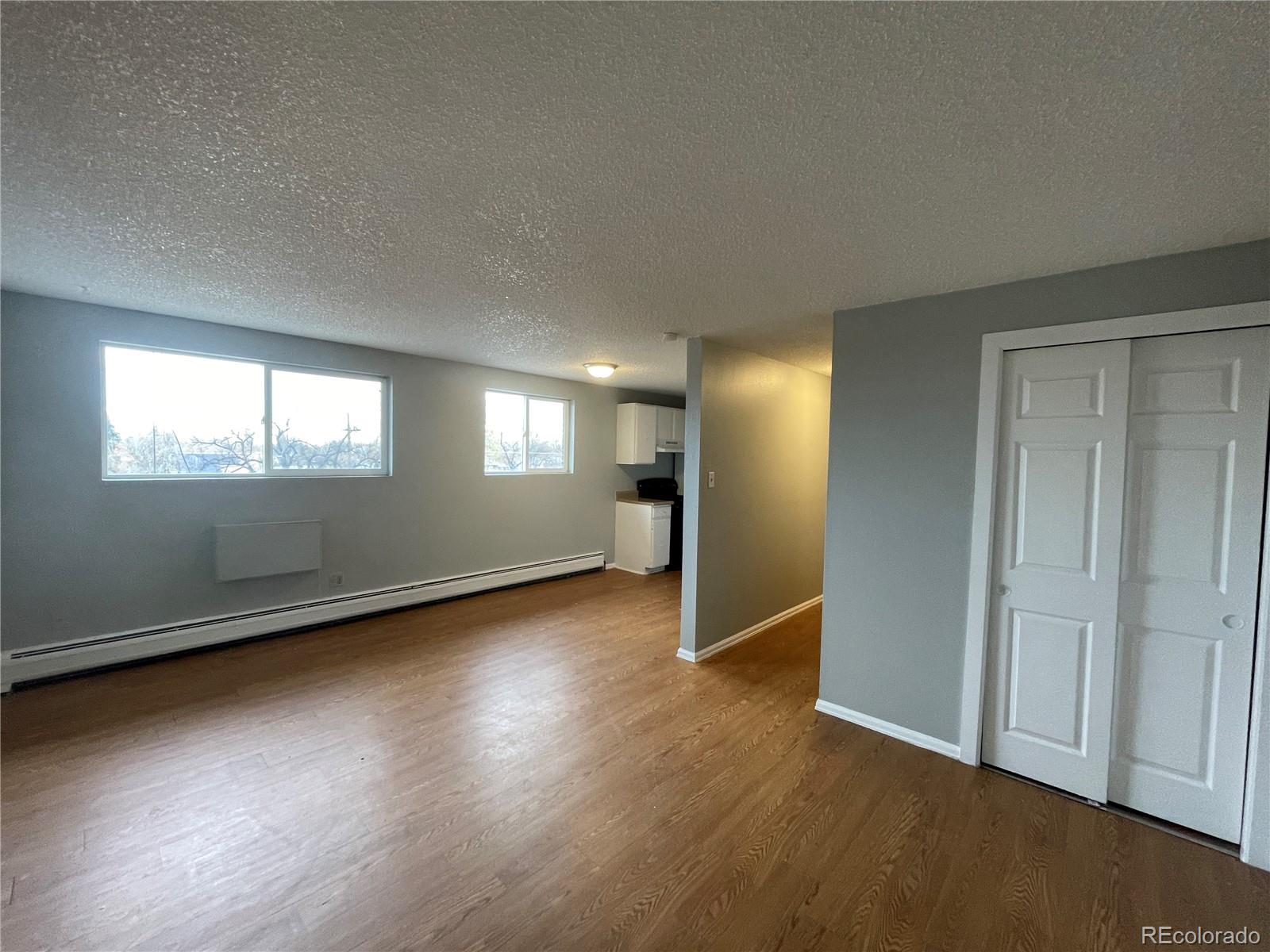 1676 Hanover Street, Unit 304 Aurora, CO 80010 - Photo 1 of 11 an empty room with wooden floor and windows