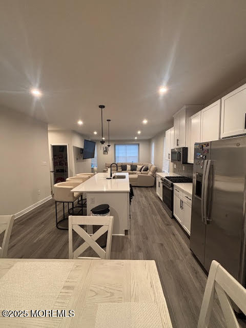 1 Halifax Road Bayville, NJ 08721 - Photo 21 of 45 a kitchen with stainless steel appliances kitchen island granite countertop a sink a stove a refrigerator cabinets and a dining table with wooden floor