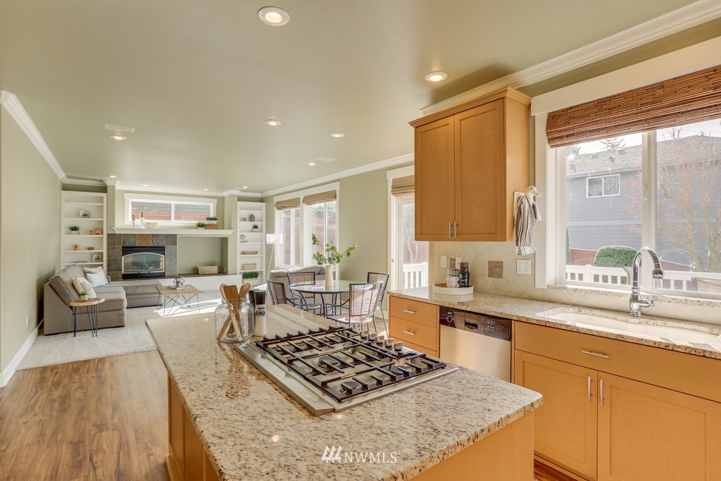 1205 North 27th Place Renton, WA 98056 - Photo 14 of 37 a kitchen with stainless steel appliances granite countertop a stove top oven a sink dishwasher and white cabinets with wooden floor
