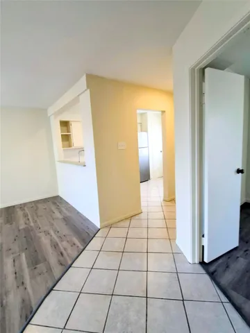 a view of a livingroom with wooden floor and a bathroom space