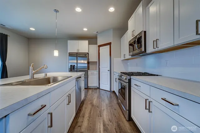 a kitchen with stainless steel appliances granite countertop a sink and microwave