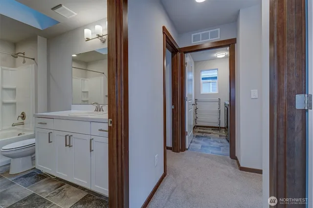 a bathroom with a granite countertop sink mirror and toilet