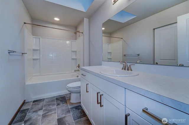 a bathroom with a double vanity sink toilet mirror and shower