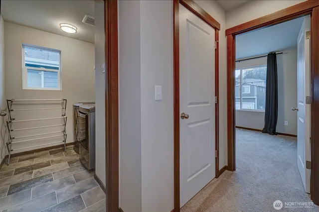 a view of a hallway with closet and a living room