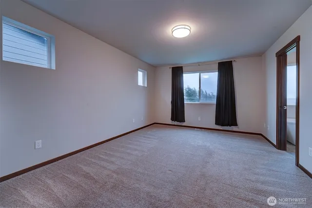 an empty room with a window and closet area