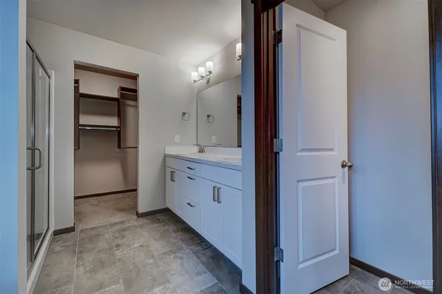 a bathroom with a glass shower door and a mirror