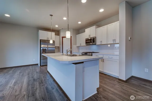 a large kitchen with stainless steel appliances kitchen island granite countertop a stove a sink and a refrigerator