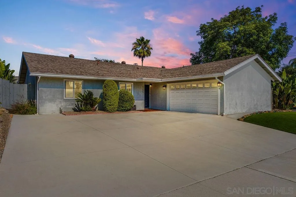 front view of a house with a yard and a garage