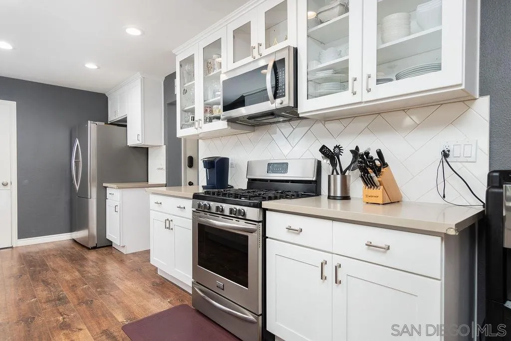 6205 Ruby Lake Avenue San Diego, CA 92119 - Photo 11 of 25 a kitchen with stainless steel appliances granite countertop white cabinets and a stove