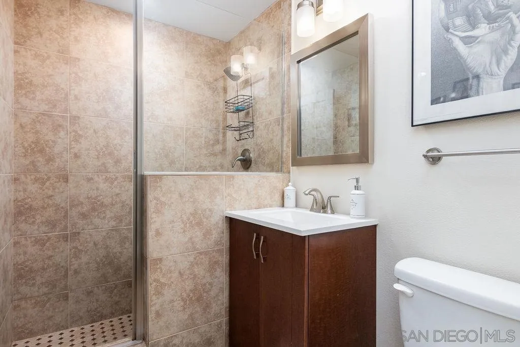 6205 Ruby Lake Avenue San Diego, CA 92119 - Photo 18 of 25 a bathroom with a toilet a sink a mirror a vanity and shower