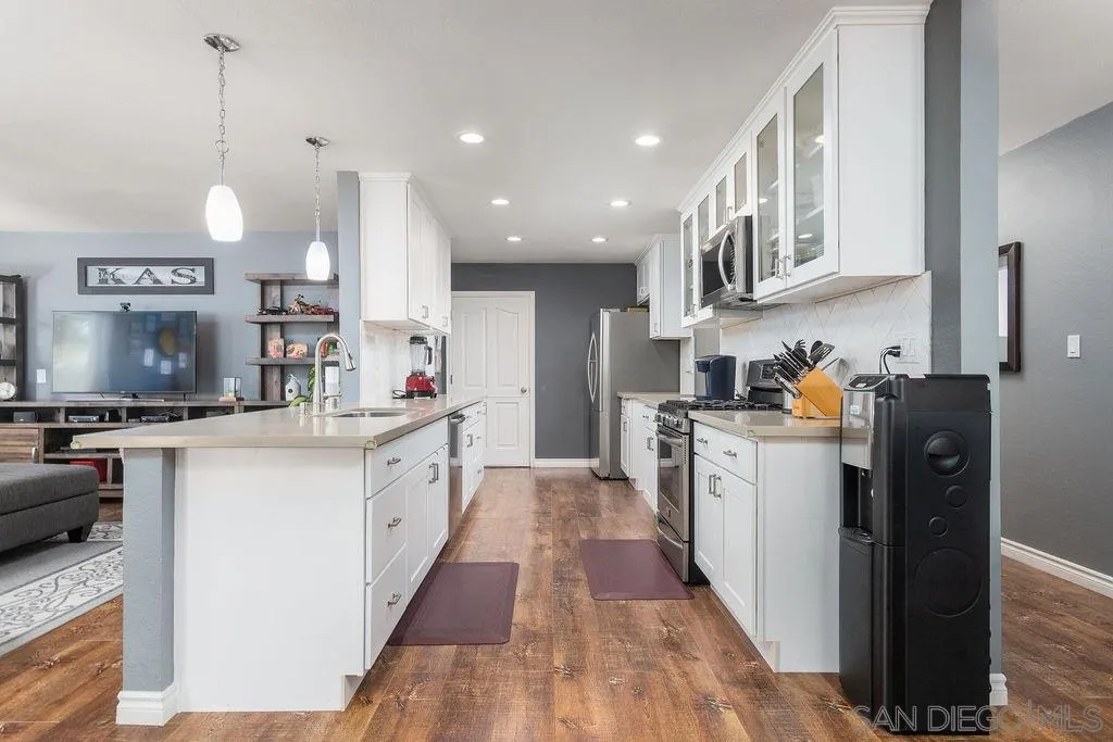 6205 Ruby Lake Avenue San Diego, CA 92119 - Photo 10 of 25 a kitchen with stainless steel appliances a stove top oven a sink a counter top space and cabinets