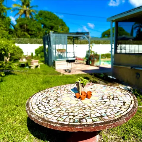 a view of a swimming pool with a yard from a porch