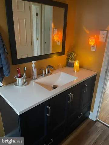 a bathroom with a sink vanity and mirror