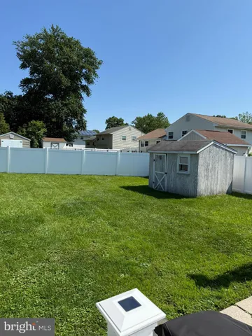 a view of a house with a big yard and large trees