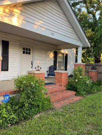 a front view of a house with a yard and outdoor seating