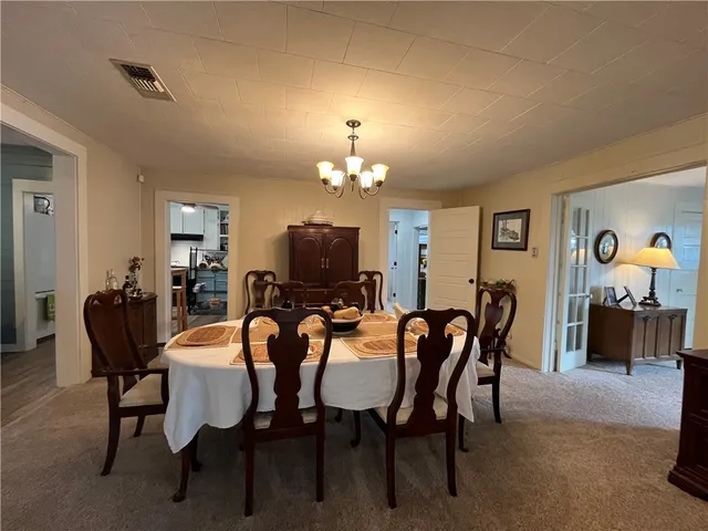 a view of a dining room with furniture and chandelier