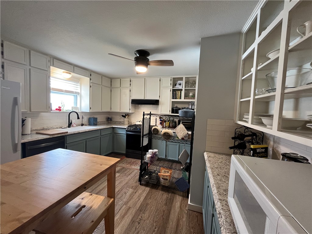 1102 North Travis Avenue Cameron, TX 76520 - Photo 22 of 48 a kitchen with a sink a stove and a refrigerator