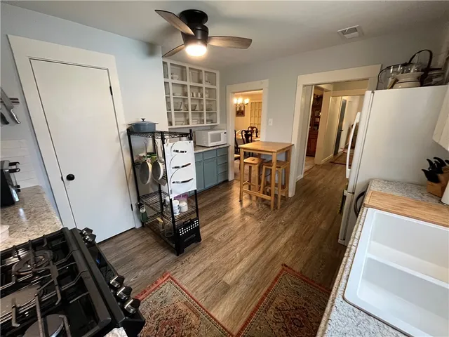 a view of a kitchen with fridge and wooden floor