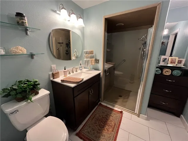 a bathroom with a sink vanity granite and toilet