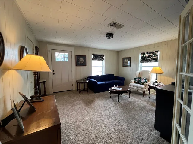 a living room with furniture a window and a flat screen tv