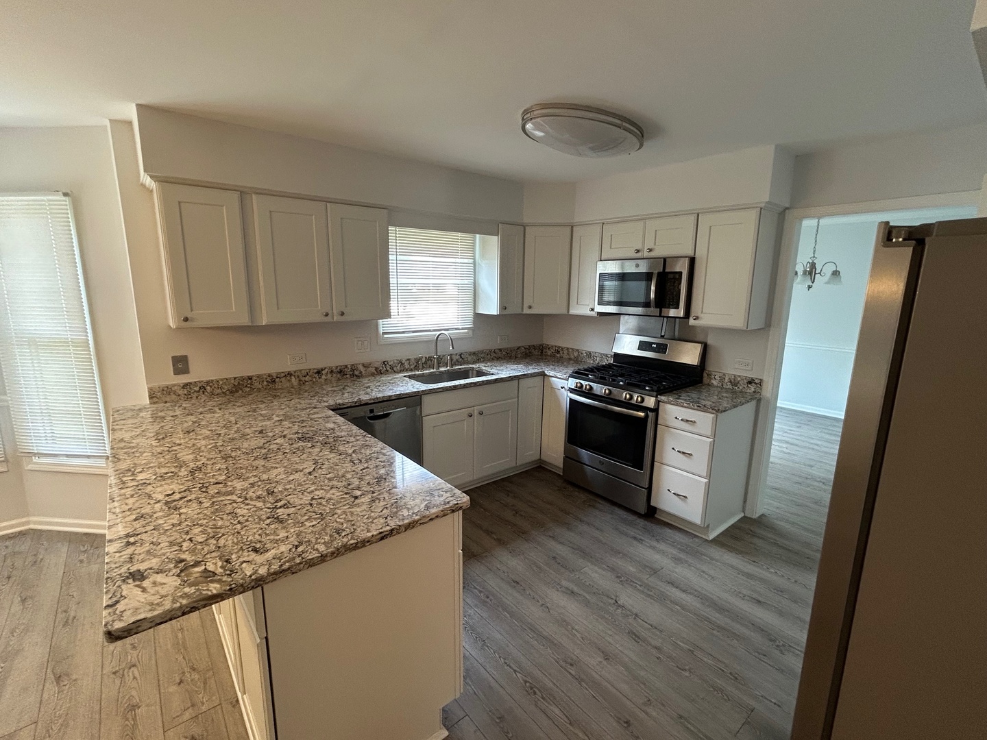 105 Golfview Circle Prospect Heights, IL 60070 - Photo 12 of 23 a kitchen with granite countertop a refrigerator a sink a stove a microwave and wooden floors