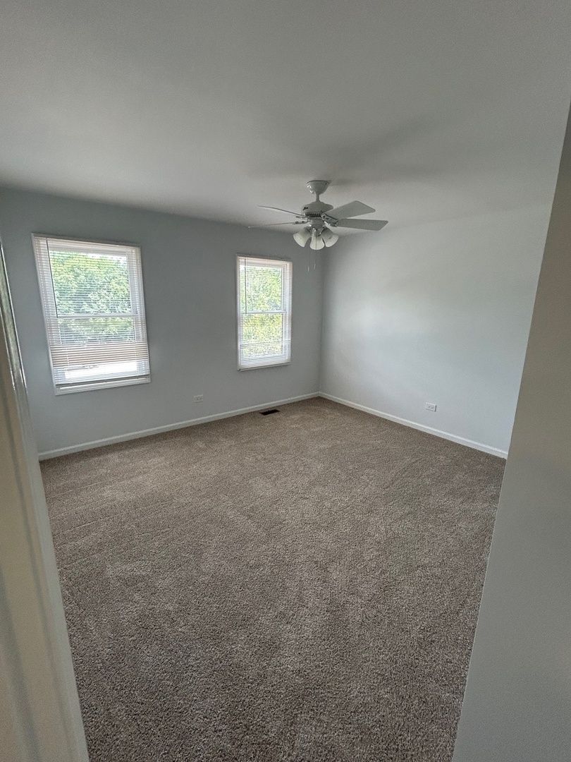 105 Golfview Circle Prospect Heights, IL 60070 - Photo 17 of 23 an empty room with windows and chandelier fan